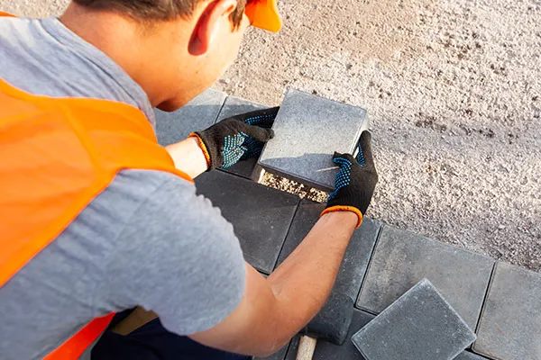 A technician inspecting freshly cast pavers